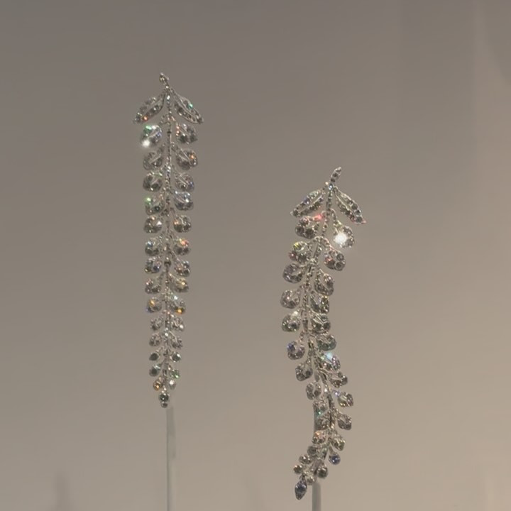 Pair of long, platinum and diamond earrings with a delicate vine motif.