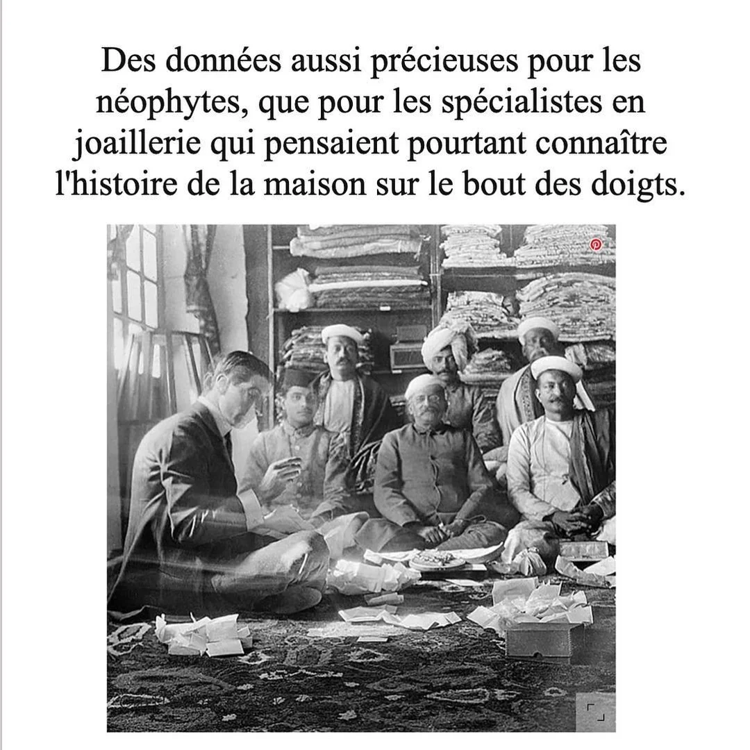 Vintage Louis Cartier and Indian men examining wrapped jewels on a patterned rug.